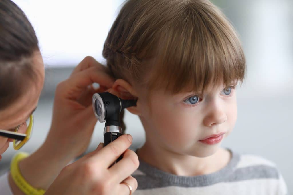 Little girl has her ear examined by a physician in Austin, Texas.